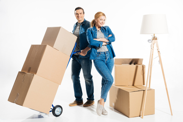 Couple moving cardboard boxes on hand cart isolated on white - Foto, Imagem