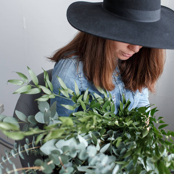 Florist makes a bouquet. Process of work. woman holding a bouquet of eucalyptus in hands - Foto, immagini