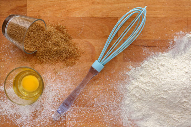 Baking ingredients - flour, sugar, egg on wood table. - Photo, Image