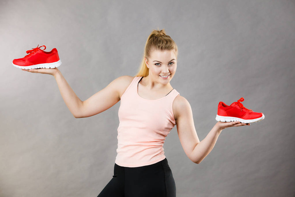 Happy woman presenting sportswear trainers shoes - Foto, Imagem