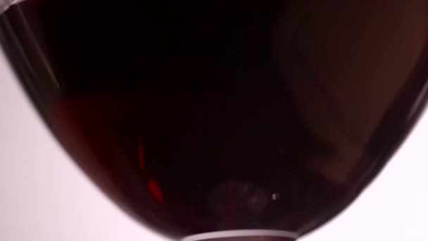 Slow motion clip of red wine in a wine glass close up - Filmati, video