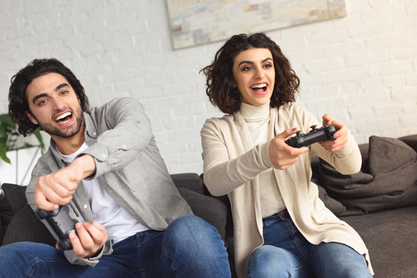 laughing young couple playing video game at home - Foto, Bild