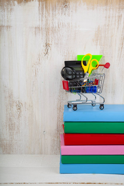Items for school in a shopping trolley and books - Foto, Imagem