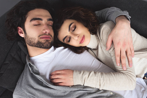 high angle view of young couple sleeping and hugging at home - Photo, Image