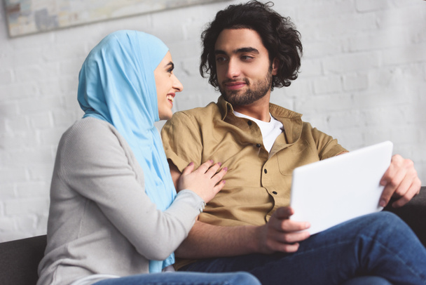 smiling muslim couple using tablet at home - Valokuva, kuva