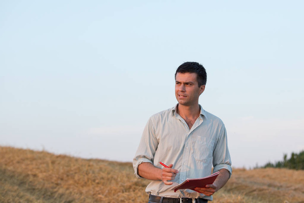 Farmer with notebook in field - Fotó, kép