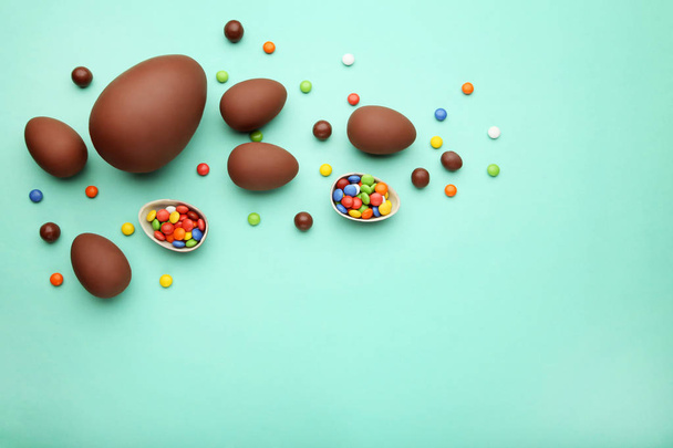 Chocolate easter eggs with colorful candies on mint background - Fotografie, Obrázek