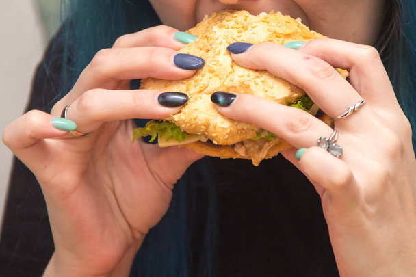 Detailní záběr z rukou člověka drží vynikající Burger a jíst ji - Fotografie, Obrázek