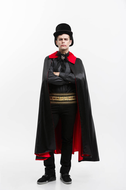 Vampire Halloween Concept - Retrato completo del apuesto vampiro caucásico en traje de halloween negro y rojo
.  - Foto, Imagen