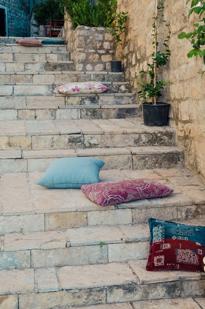 Escaleras con almohadas y arco de piedra en el casco antiguo de Ulcinj, Montenegro
. - Foto, Imagen