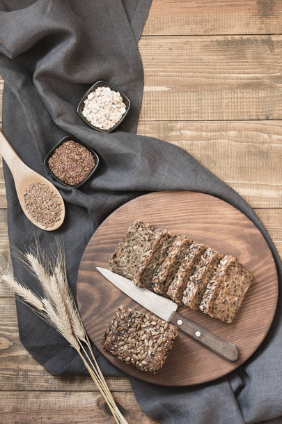 Loaf of rye bread sliced and ingredients on cutting board. Close up. - 写真・画像