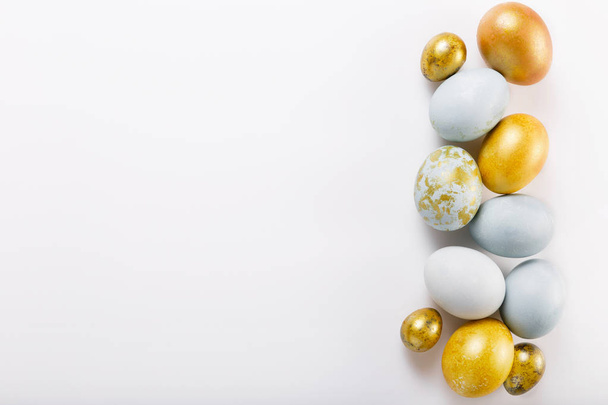 Easter background with Easter eggs and spring flowers. Top view with copy space - Photo, Image