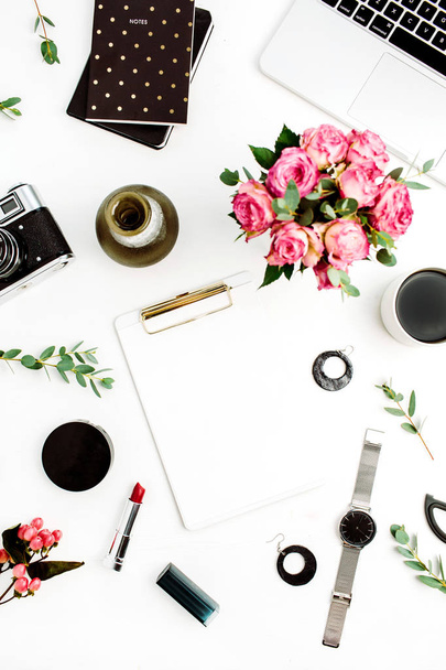 Female home office workspace with clipboard, laptop, rose flowers, eucalyptus branches, fashion accessories and cosmetics. Flat lay, top view fashion mockup. - Photo, Image