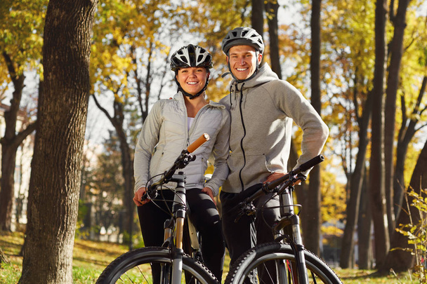 backlight photo of a couple having fun by bike - Фото, изображение