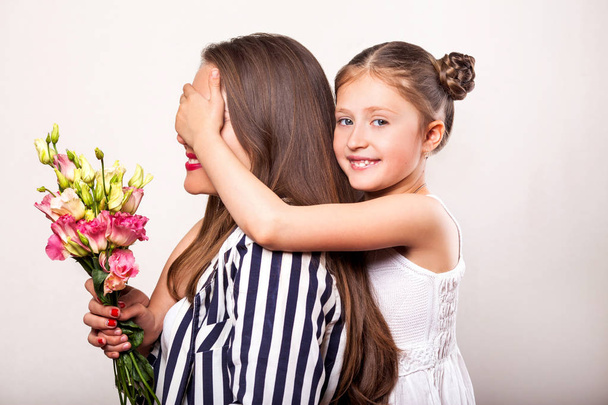 Κόρη δίνει τα λουλούδια στη μητέρα της την ημέρα της μητέρας - Φωτογραφία, εικόνα