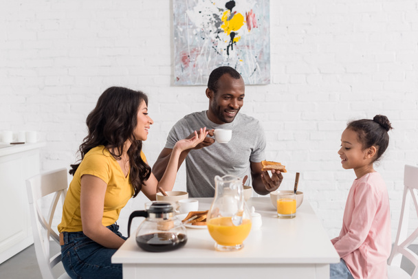 beautiful young family having breakfast on kitchen together - Photo, Image