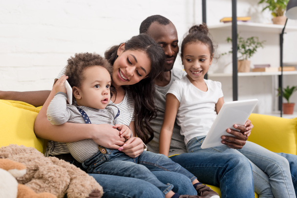 happy young family spending time together with devices at home - Foto, imagen