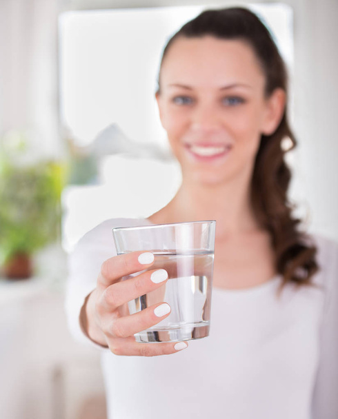 Woman offering glass of water - 写真・画像