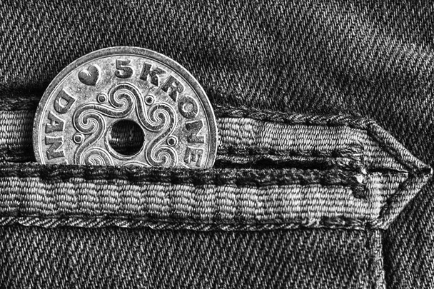 Деноминация монет Дании пять крон (корона) в кармане изношенных джинсов с полосой, монохромный выстрел
 - Фото, изображение