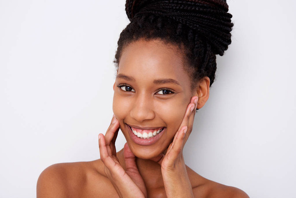 Portret van Afro-Amerikaanse vrouwelijke mannequin met handen close-up door gezicht tegen de witte achtergrond - Foto, afbeelding