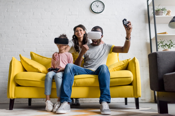 heyecanlı baba ve anne arkasında oturan ve izlerken sırasında video oyunları oynarken kızı - Fotoğraf, Görsel