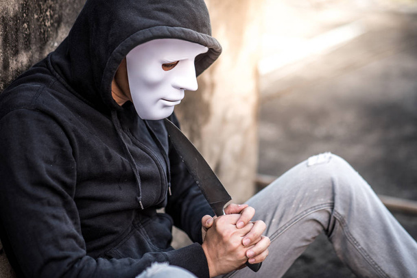 Hombre misterioso con máscara blanca considerando suicidarse con cuchillo
 - Foto, imagen