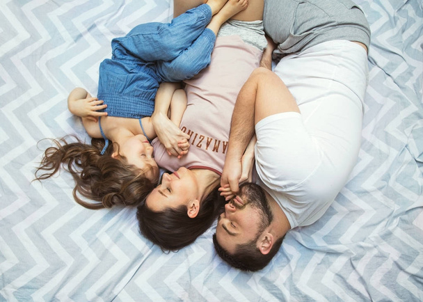 happy family lying on the bed, top view - Foto, imagen