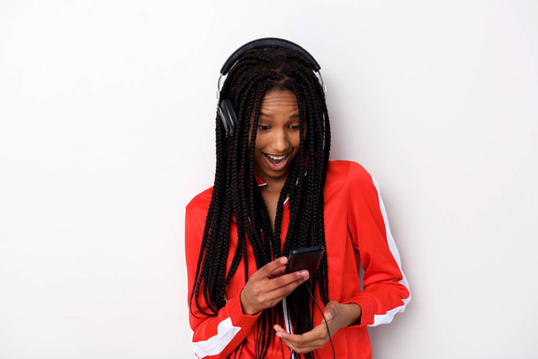 Πορτρέτο του Νεαρή Αφρικανή γυναίκα με τα ακουστικά στο έξυπνο τηλέφωνο - Φωτογραφία, εικόνα