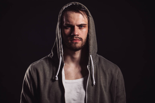 horizontal photo of rocker with blue eyes wearing hoodie and white shirt - Foto, afbeelding