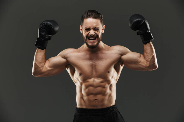 Portrait of an excited muscular sportsman celebrating - Zdjęcie, obraz