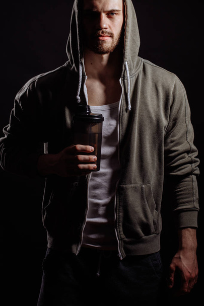 cropped portrait of Caucasian hood man standing with thermos. a sip of hot tea. - Foto, Imagem