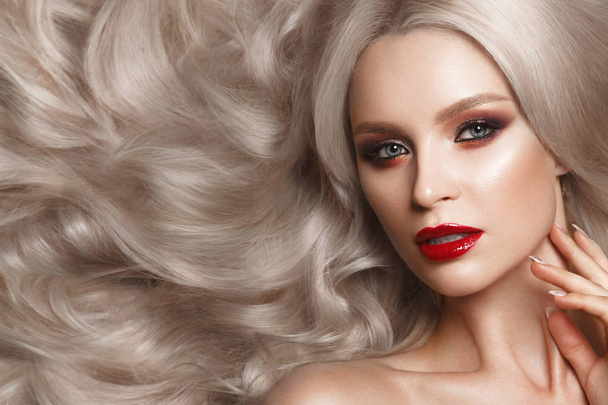 Beautiful blonde in a Hollywood manner with curls, natural makeup and red lips. Beauty face and hair. - Фото, зображення
