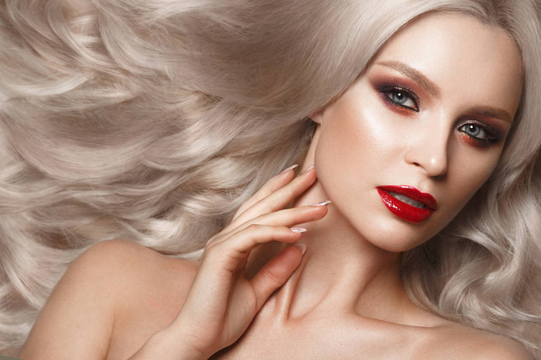 Beautiful blonde in a Hollywood manner with curls, natural makeup and red lips. Beauty face and hair. - Zdjęcie, obraz
