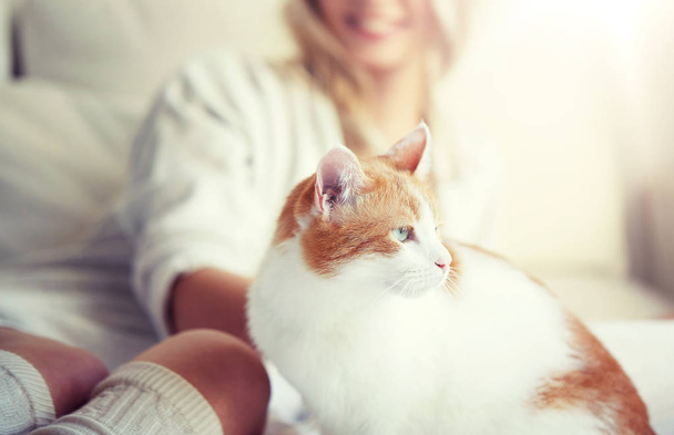 happy young woman with cat in bed at home - Photo, Image