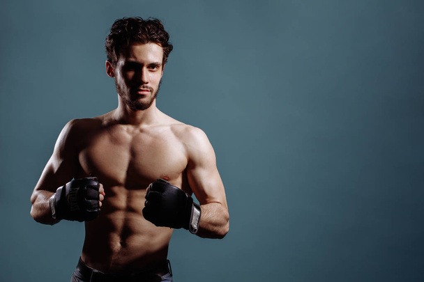 strong unshaven puglist is fighting with boxing gloves - Photo, Image