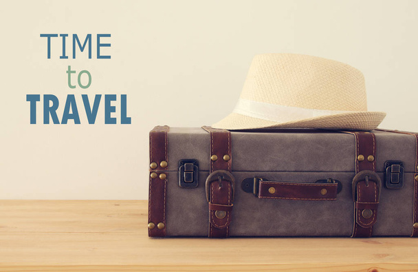 viajante bagagem vintage, câmera e chapéu fedora sobre mesa de madeira. conceito de férias e férias
. - Foto, Imagem
