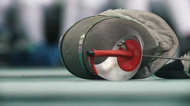 Fencing protective mask and rapier on the floor during fencing competition - Кадри, відео
