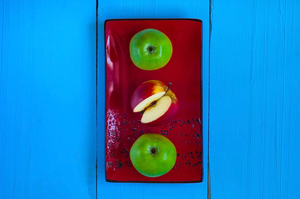 Выбор здоровой пищи для сердца, концепция жизни, яблоки на керамической текстуре на деревянном фоне синего цвета
 - Фото, изображение