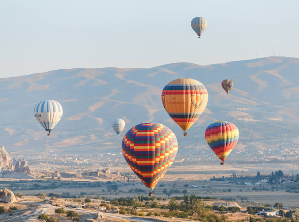 GOREME, CAPPADOCIA, TURKEY - 24 SEPTEMBER 2017: Hot air balloons flying above fantastic scenic landscape of Cappadocia - Photo, image
