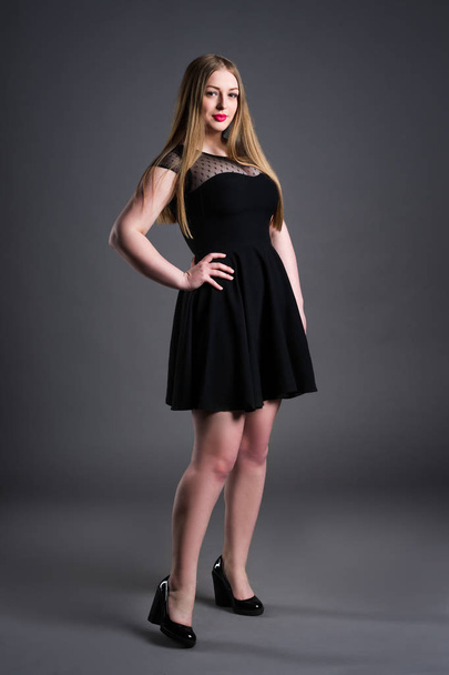 Plus size fashion model in black dress, fat woman on gray studio background, overweight female body - Photo, image
