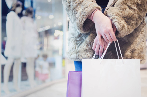Giovane donna gioiosa con borse della spesa e finestra dello shopping in background
 - Foto, immagini