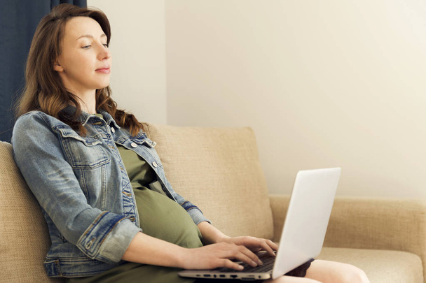 W ciąży kobieta siedząca z laptopem w domu. Freelance pracy, p - Zdjęcie, obraz