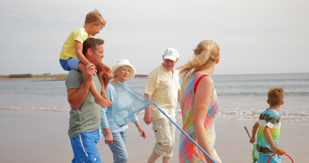 Sivunäkymä, seuranta laukaus, perheen kävely rannalla lomalla
. - Materiaali, video