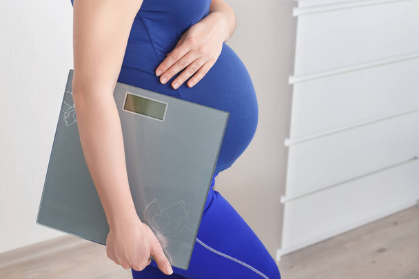 pregnant woman holding scales - Foto, imagen