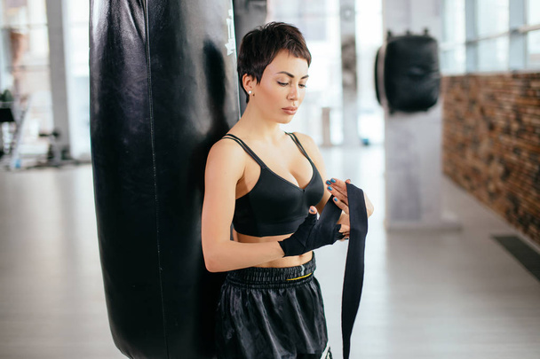 athletic nice girl wearing sportswear preparing for combat at sport gym - Fotoğraf, Görsel