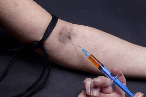 Injecting drugs with a syringe into an arm vien - Photo, Image