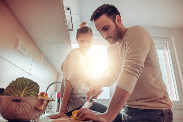 young couple cooking together in kitchen - Photo, image