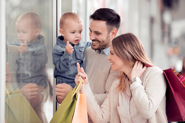 молодая семья по магазинам с маленьким сыном
 - Фото, изображение