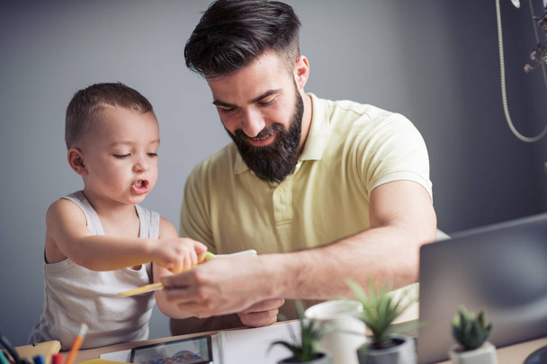 Young father spending time with toddler son at home - Foto, immagini