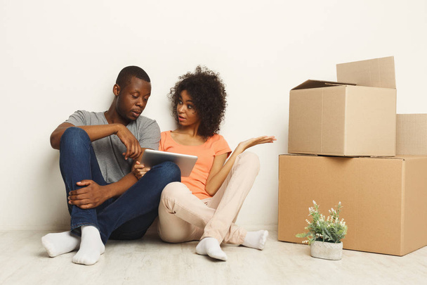casal preto sentado no chão no novo apartamento
 - Foto, Imagem